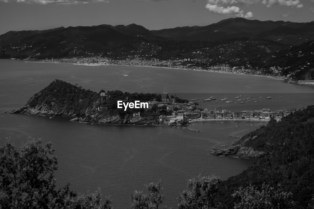 Scenic view of sea by mountains against sky