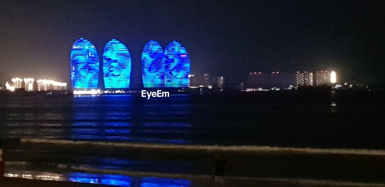 ILLUMINATED BUILDINGS AT WATERFRONT