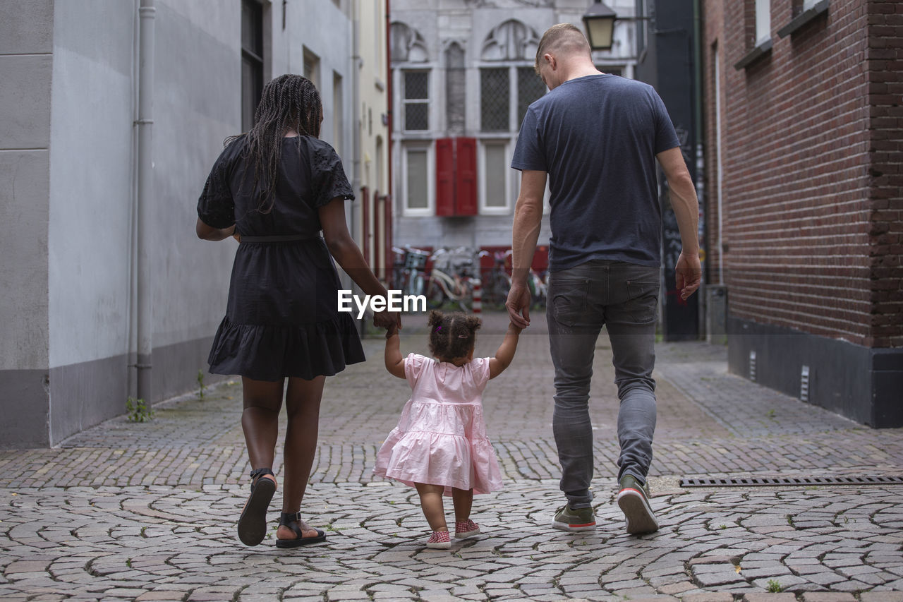 A young family walking through the streets of a european city