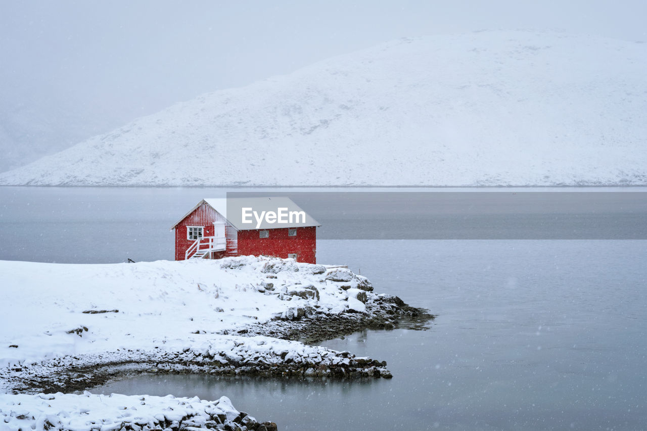 Red rorbu house in winter, lofoten islands, norway