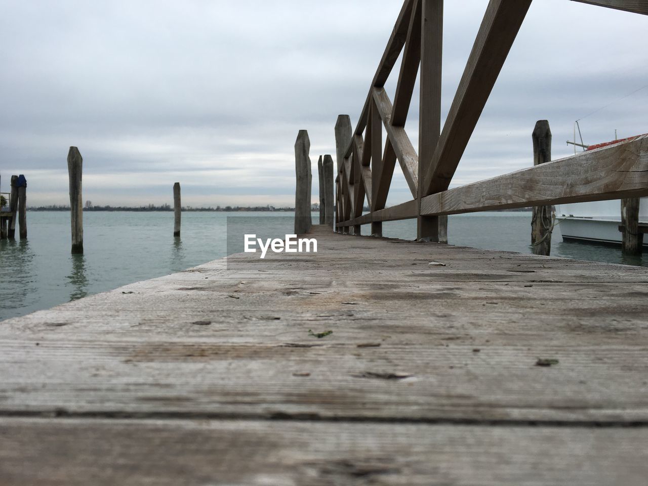 Pier on sea against cloudy sky