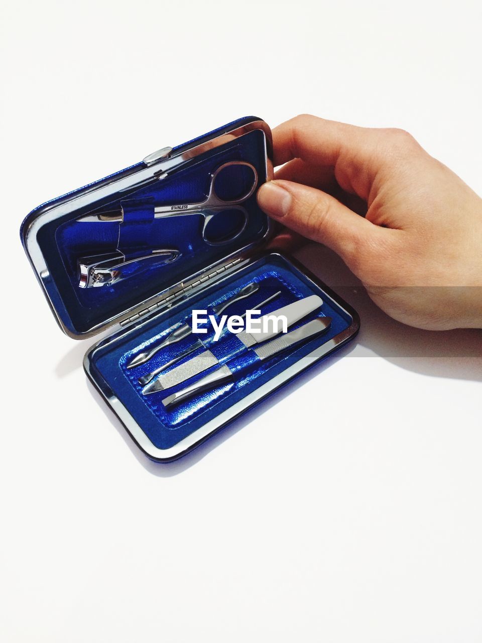 Cropped image of woman holding manicure set over white background