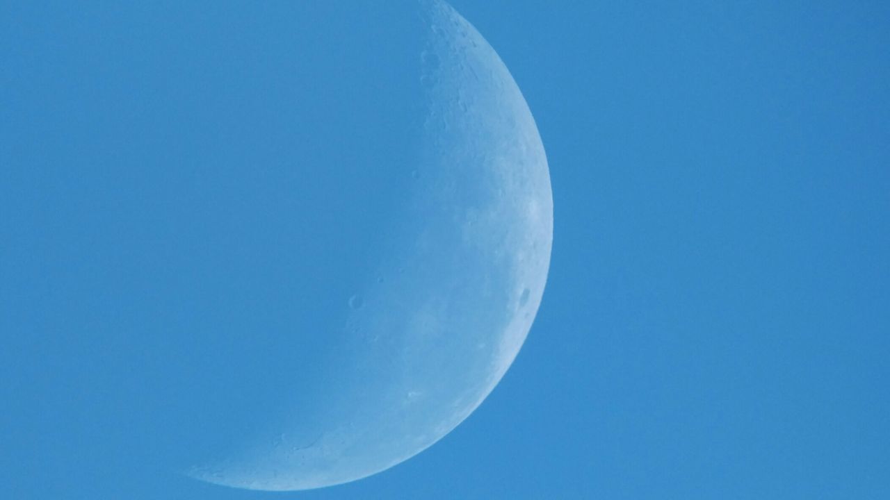 LOW ANGLE VIEW OF MOON IN BLUE SKY