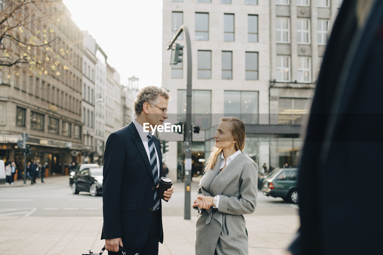 Business colleagues talking while standing in city