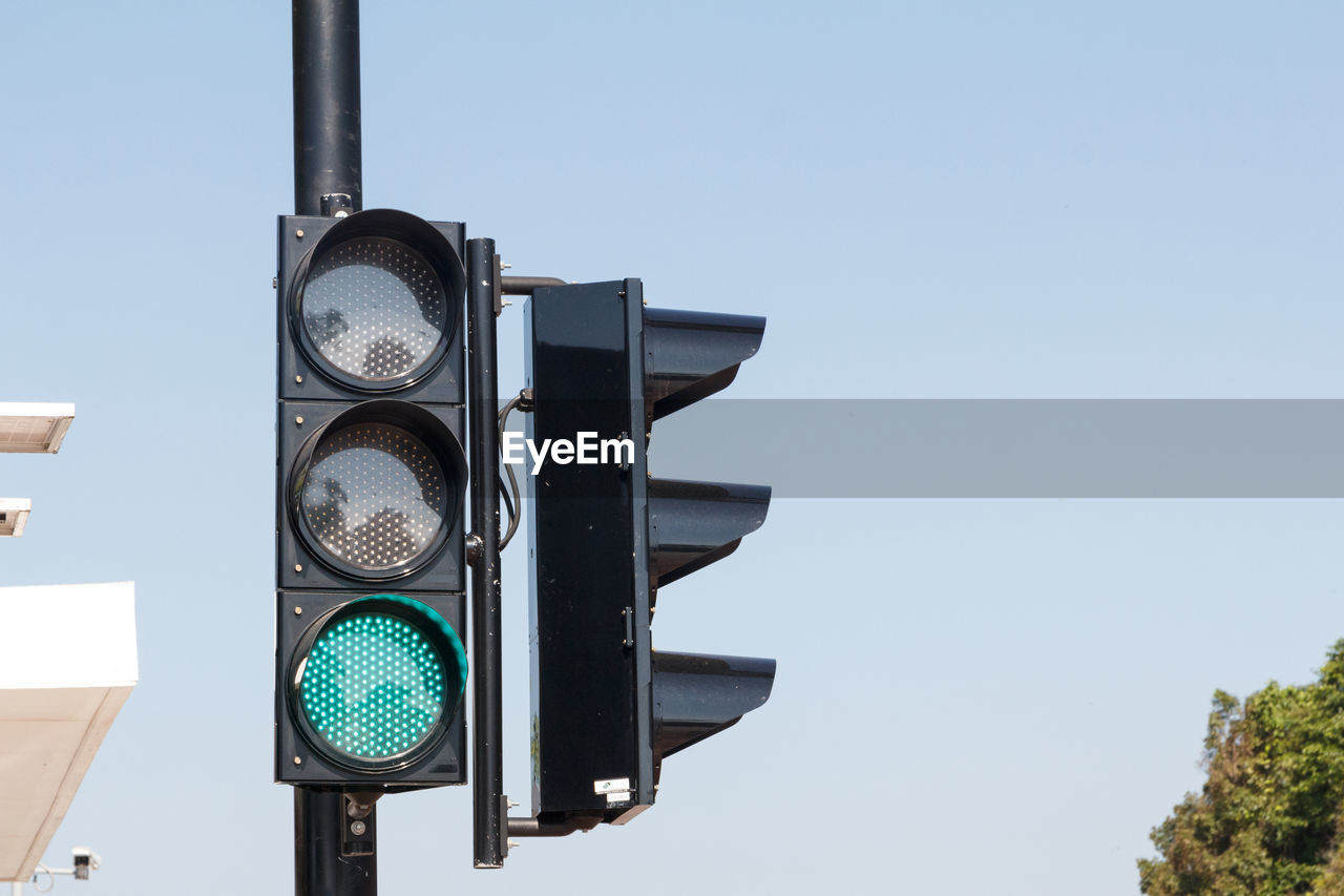 Green traffic light ,isolated on sky background