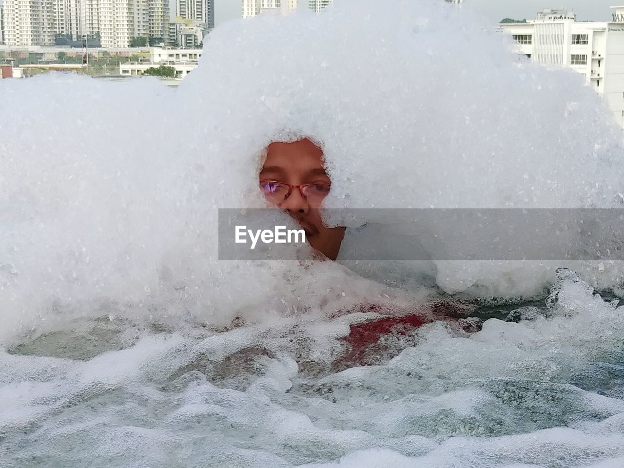 PORTRAIT OF HAPPY BOY IN WATER AT PARK