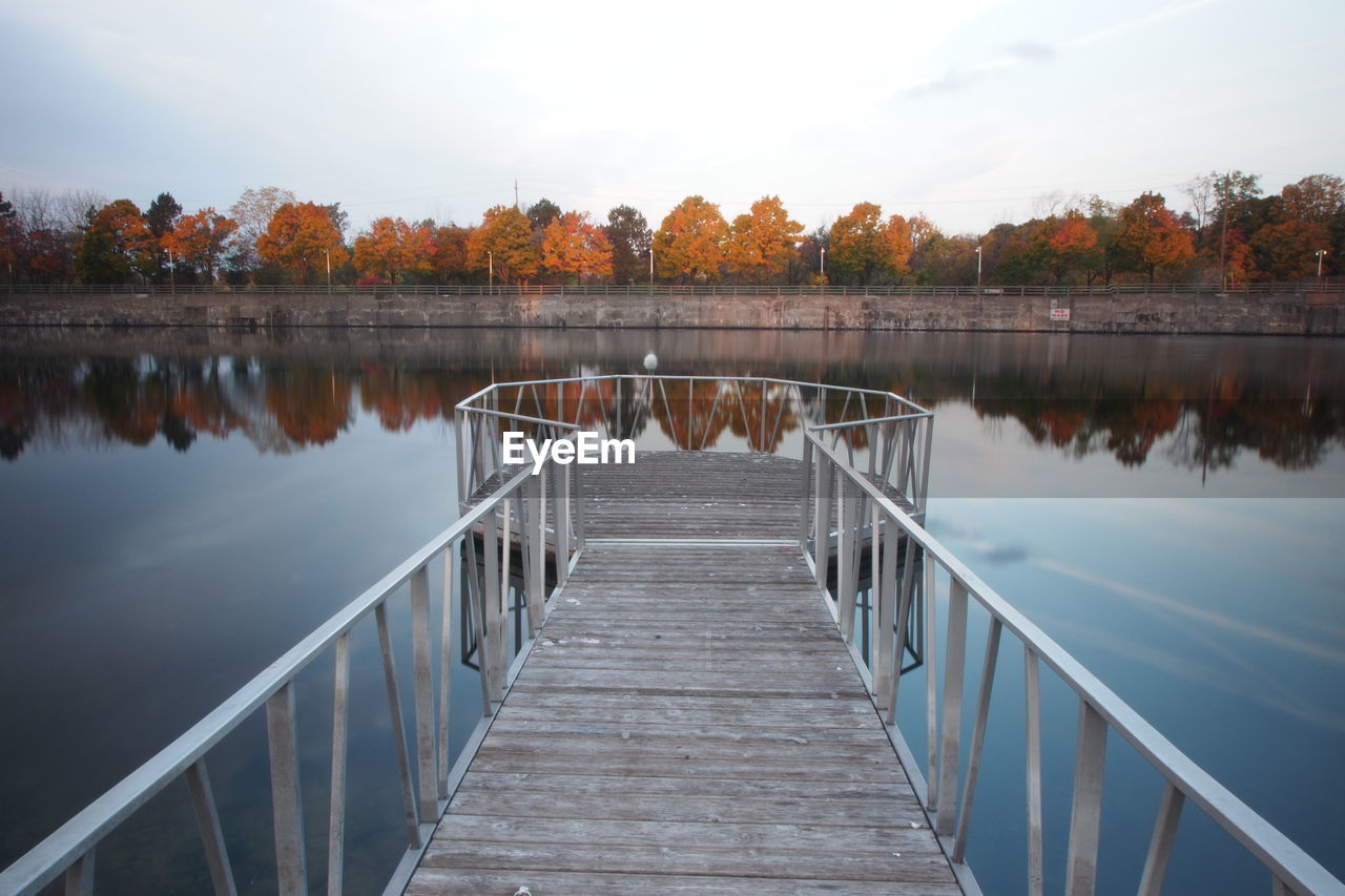 Pier over lake against sky during autumn