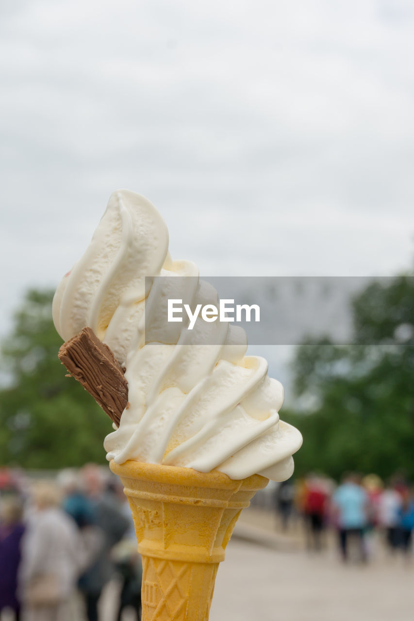 Close-up of ice cream cone against sky