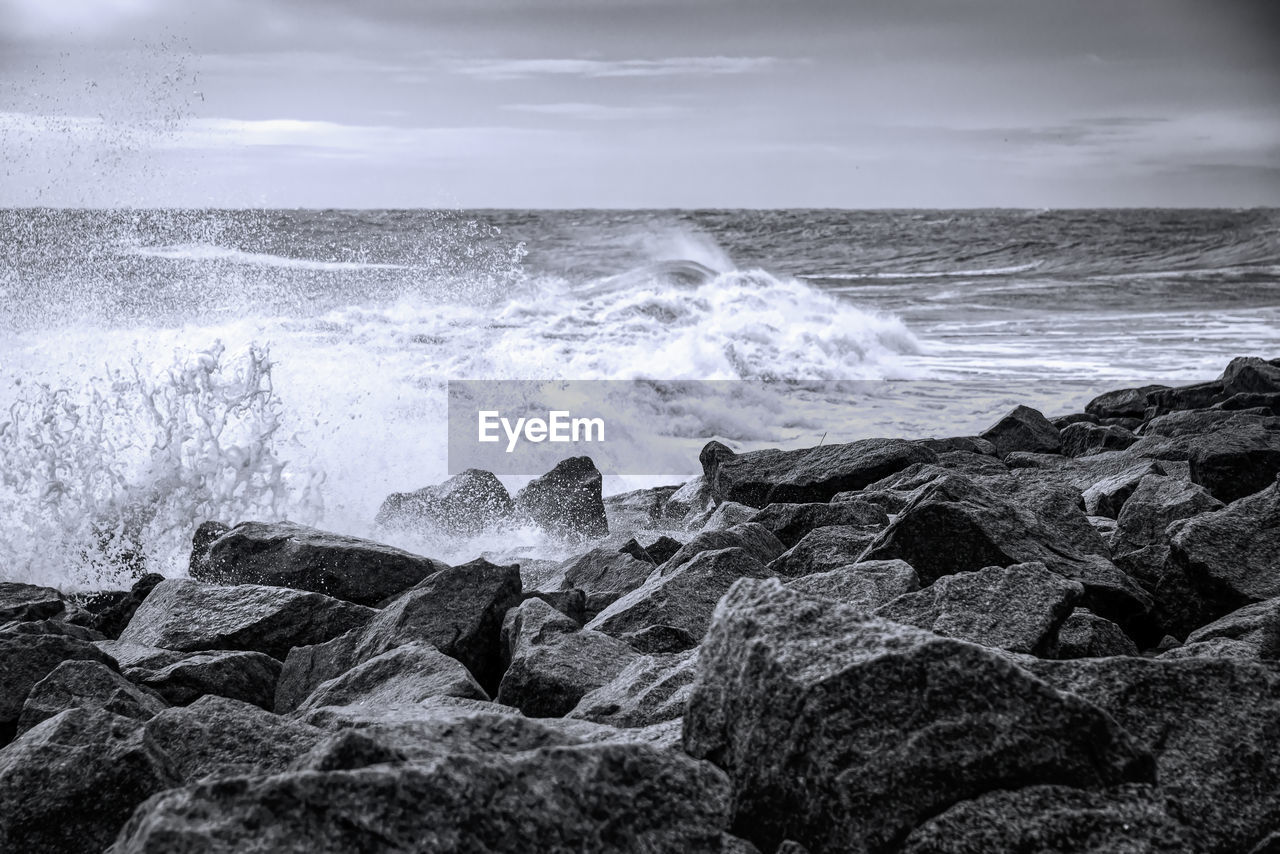 SCENIC VIEW OF SEA WAVES SPLASHING ON ROCKS