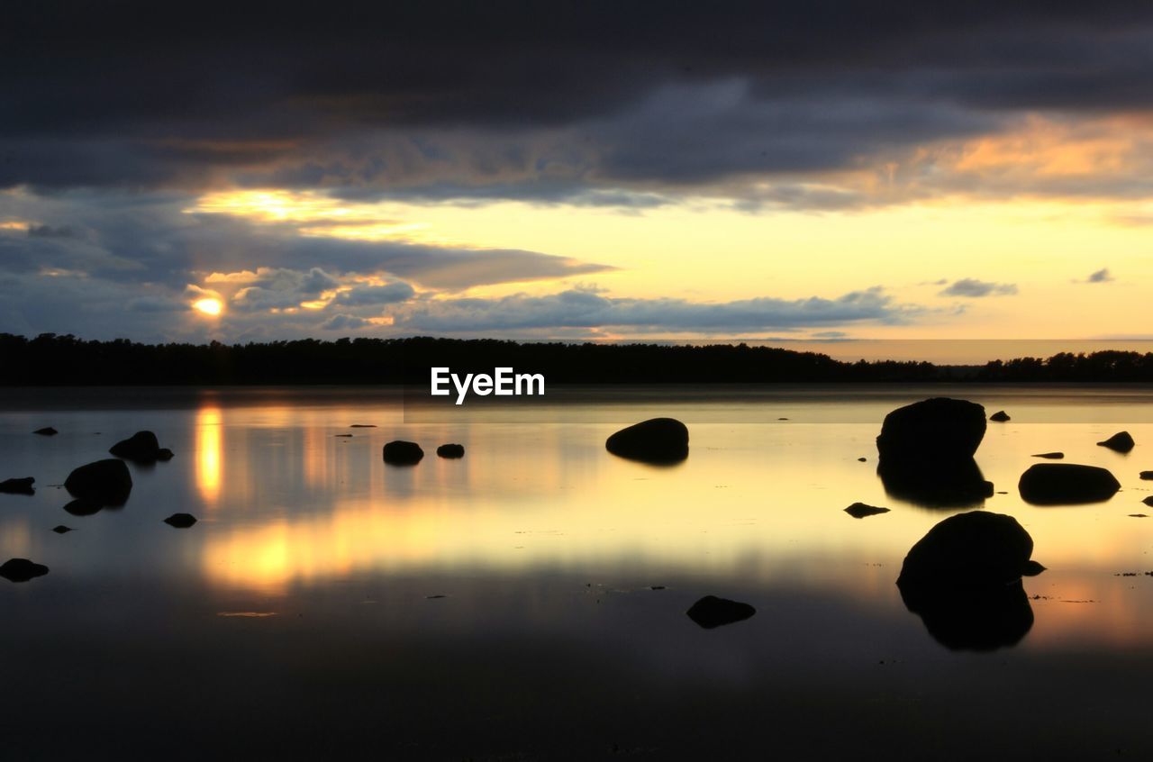 Silhouette of rocks on calm lake