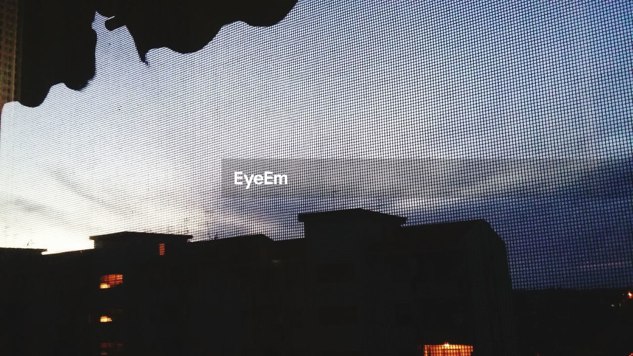 LOW ANGLE VIEW OF SILHOUETTE BUILDINGS AGAINST SKY