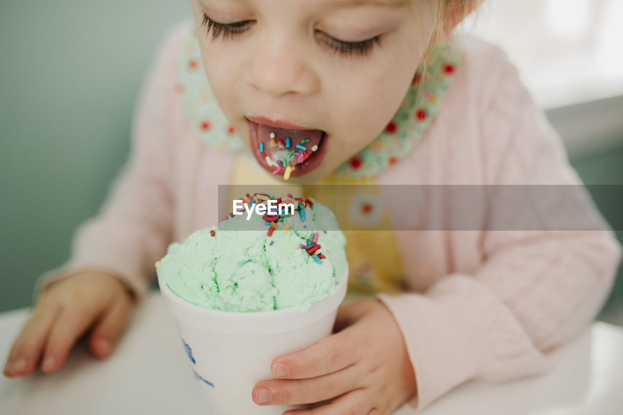 Girl eating ice cream with sprinkles