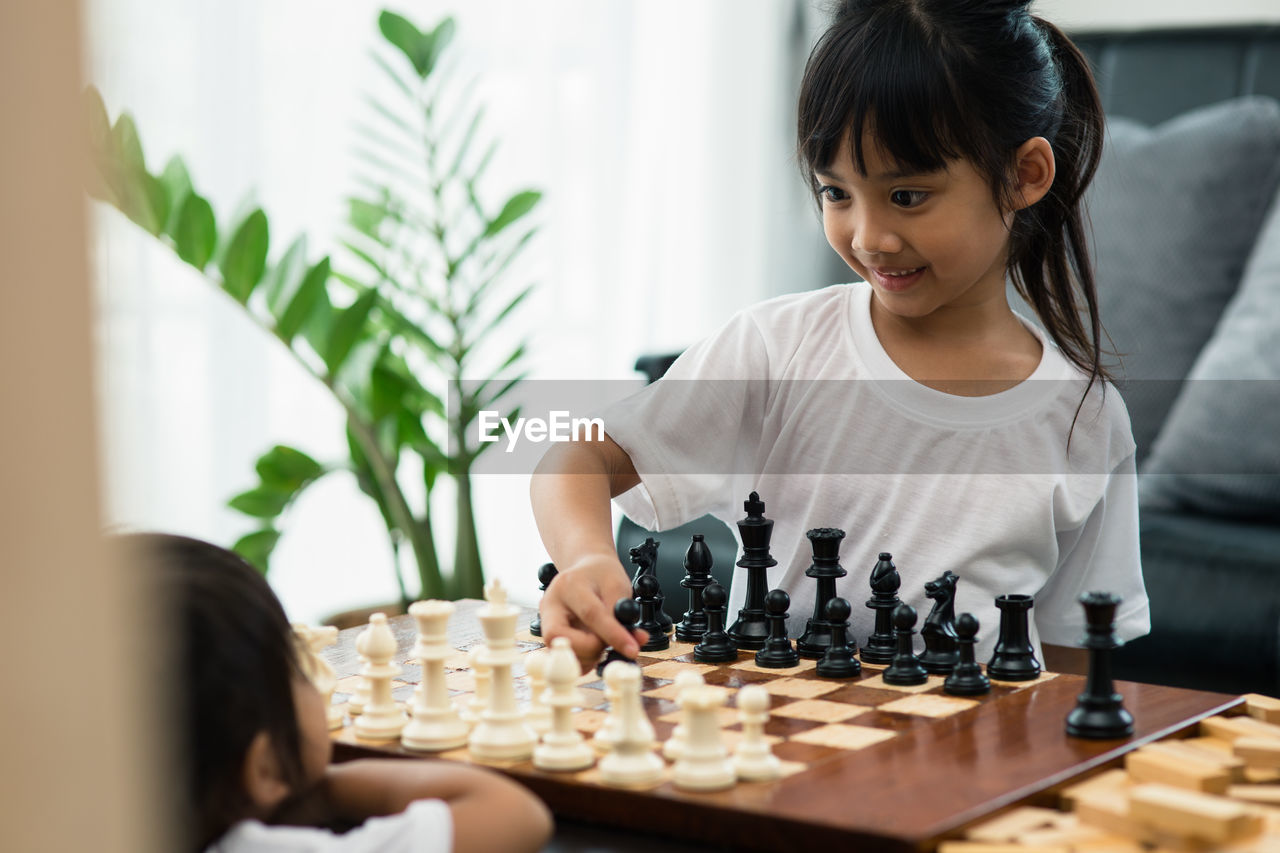 Siblings playing chess at home