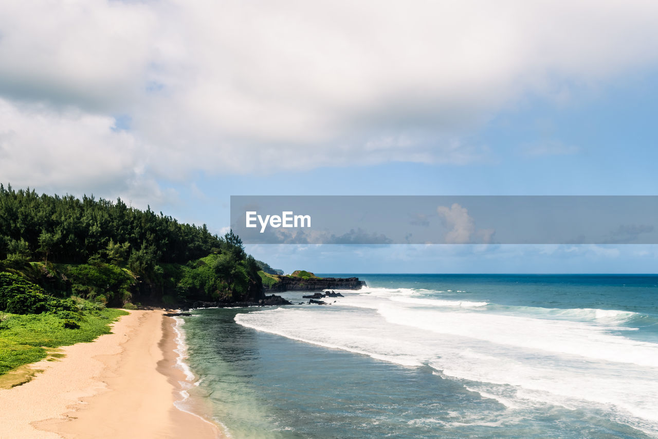 land, sea, water, beach, sky, cloud, body of water, scenics - nature, beauty in nature, sand, nature, tree, ocean, shore, vacation, travel destinations, wave, environment, coastline, travel, tranquility, holiday, coast, tropical climate, trip, plant, water's edge, motion, tourism, landscape, tranquil scene, island, surfing, water sports, sports, idyllic, horizon over water, horizon, outdoors, blue, seascape, wind wave, summer, day, non-urban scene, bay, palm tree, relaxation, cloudscape, sunlight, tropical tree, tropics, tourist resort