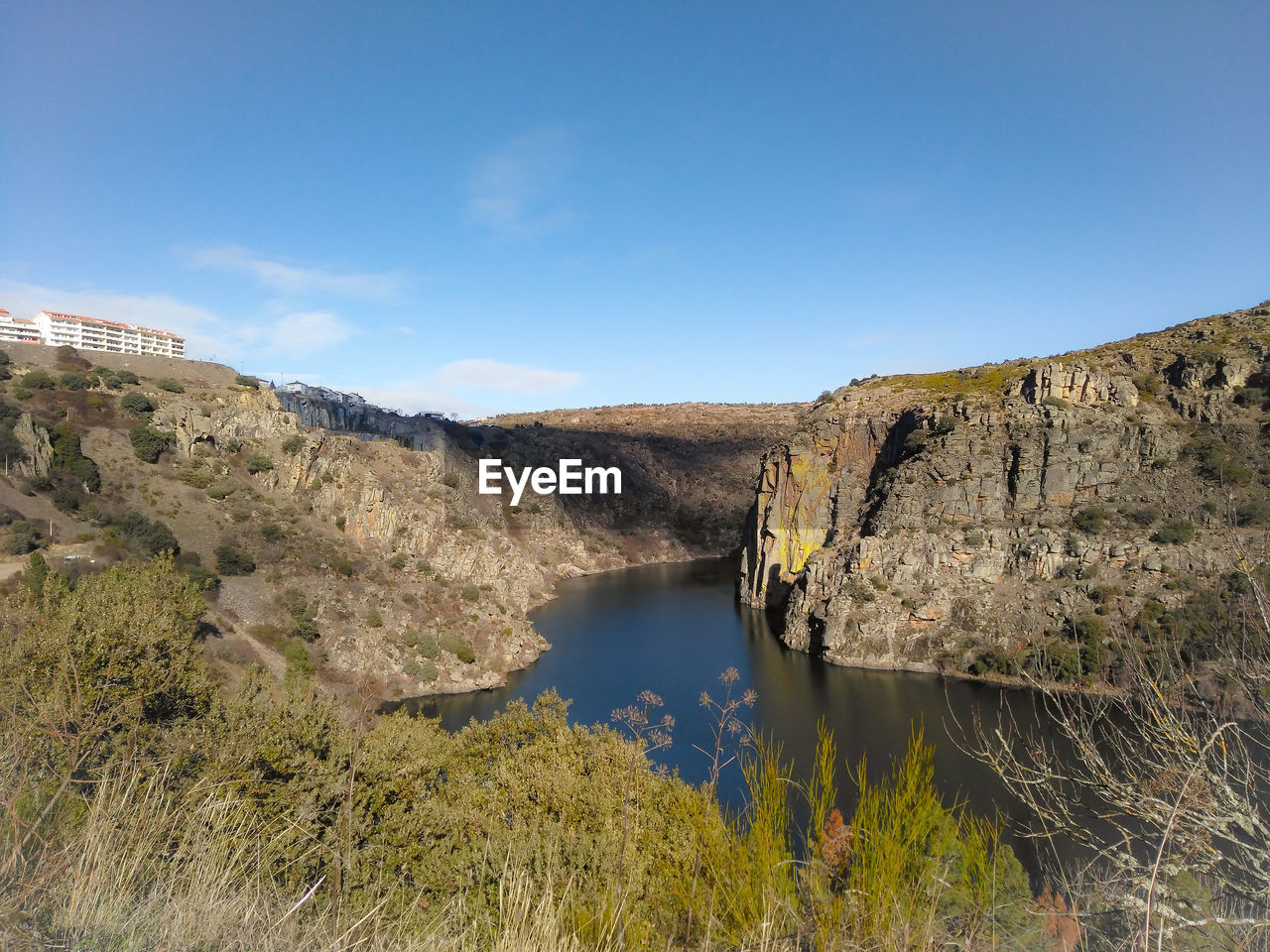 RIVER BY MOUNTAINS AGAINST SKY