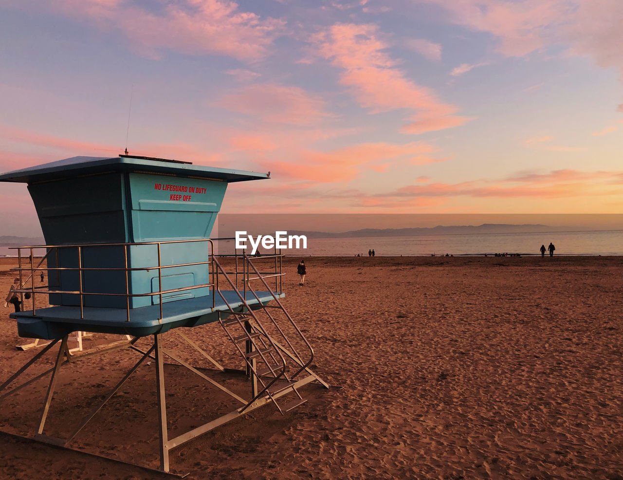 HUT ON BEACH AGAINST SKY DURING SUNSET