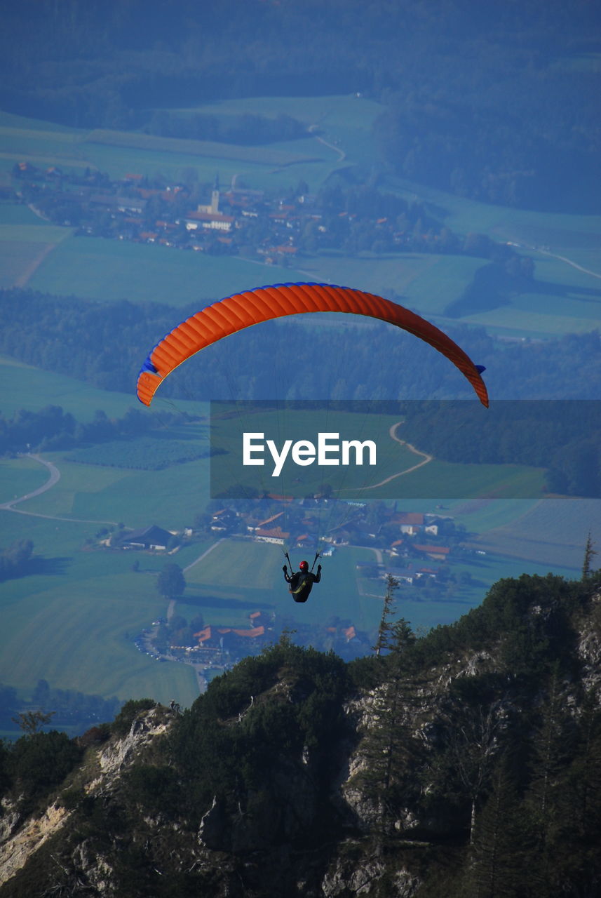 High angle view of person paragliding over mountain