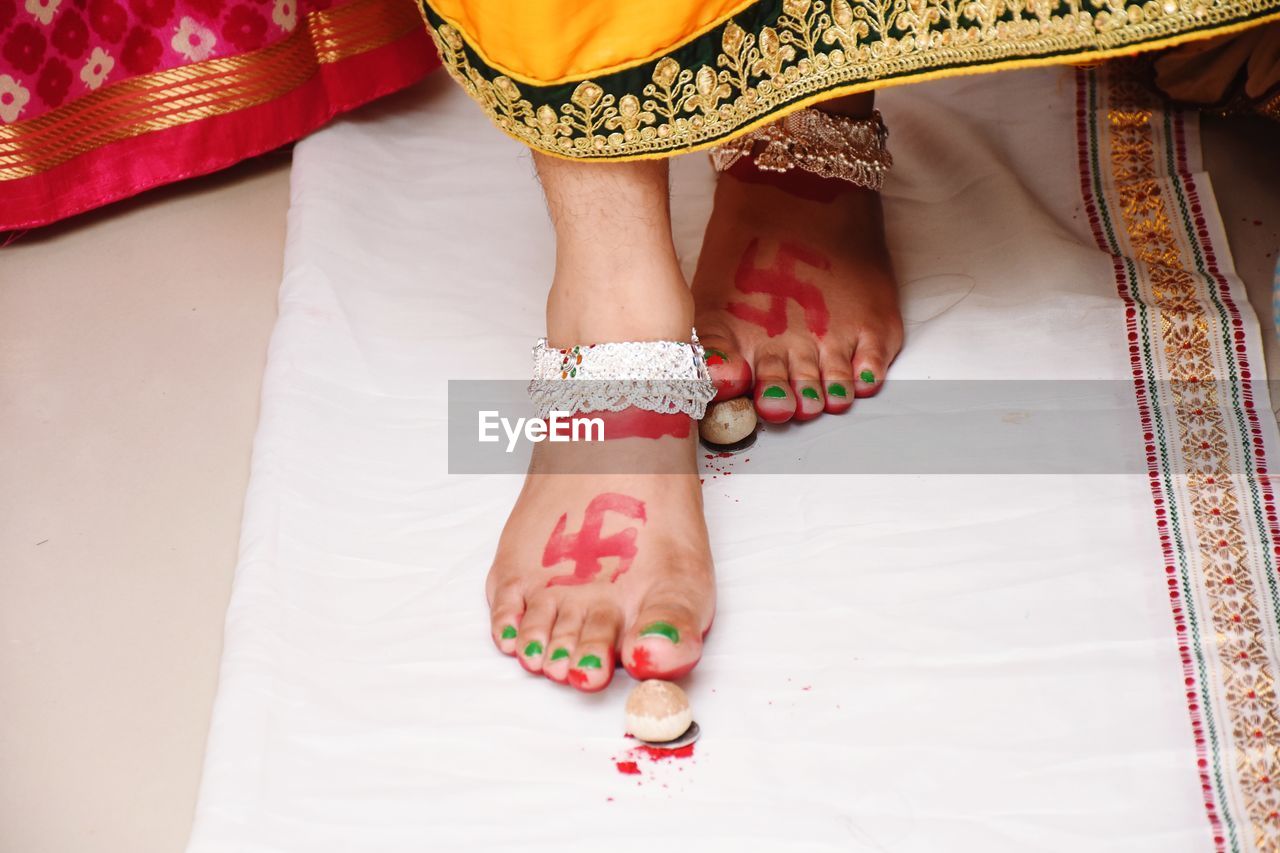 Low section of woman with painted legs walking on fabric