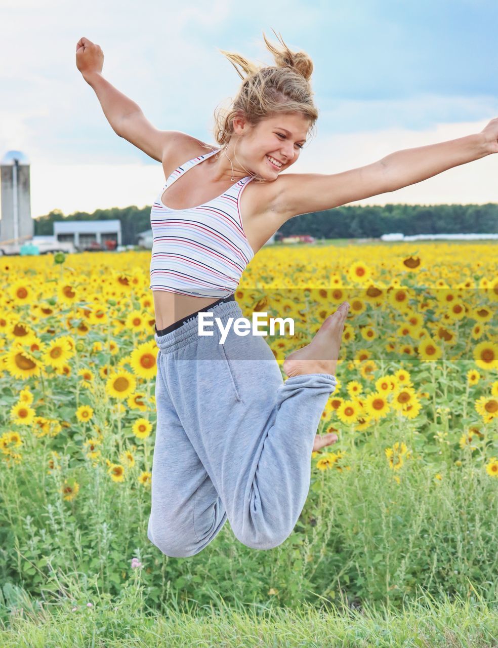 Young woman with yellow flowers on field