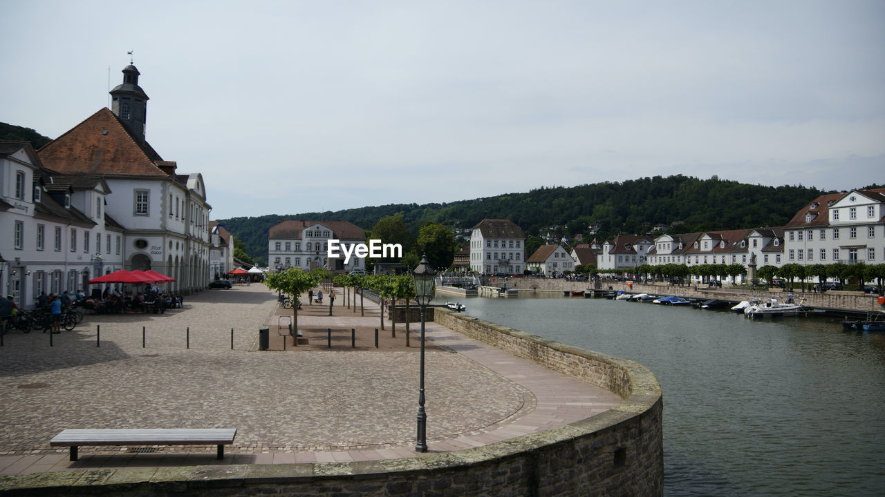 buildings by river against sky