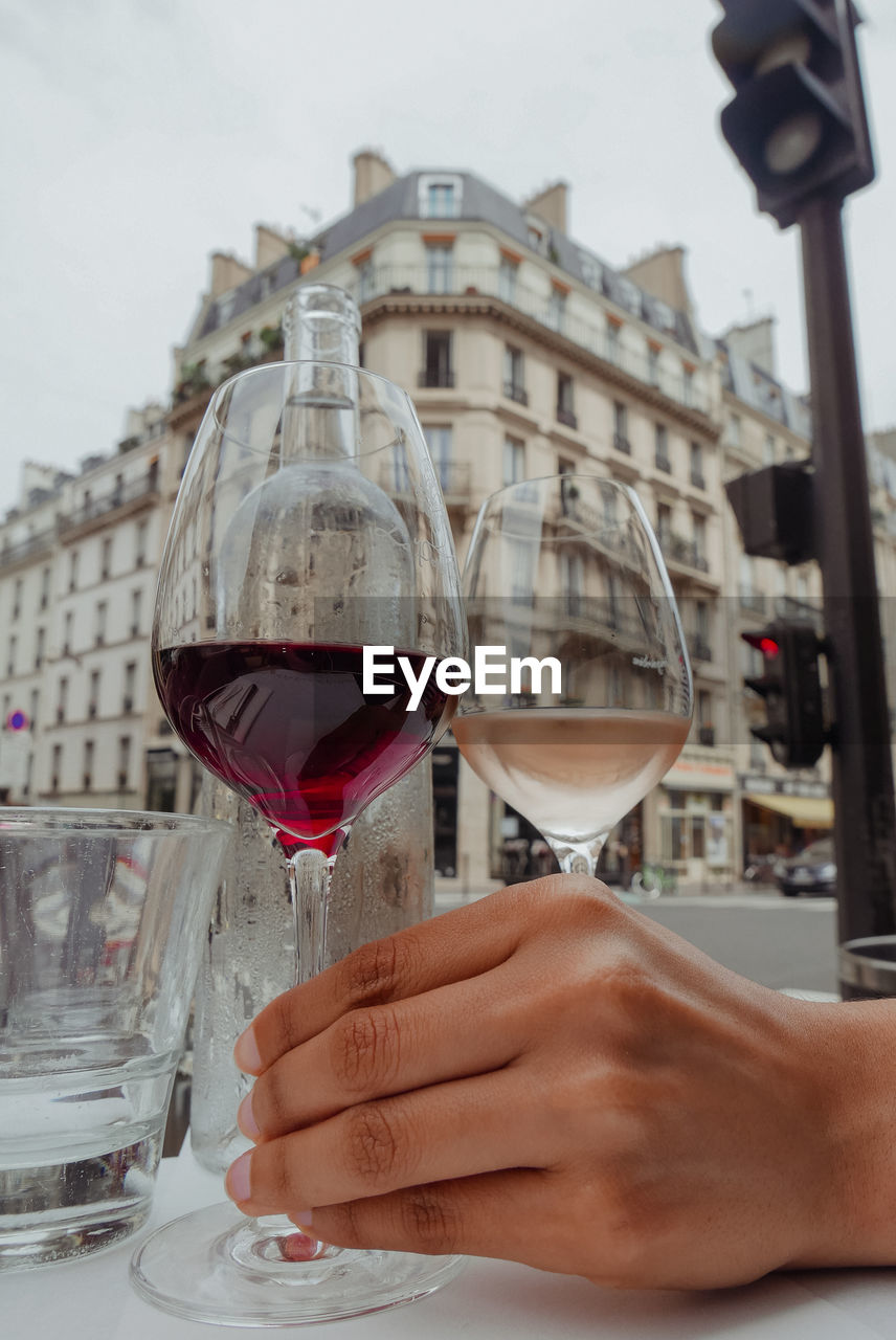 CLOSE-UP OF A HAND HOLDING GLASS OF WINE