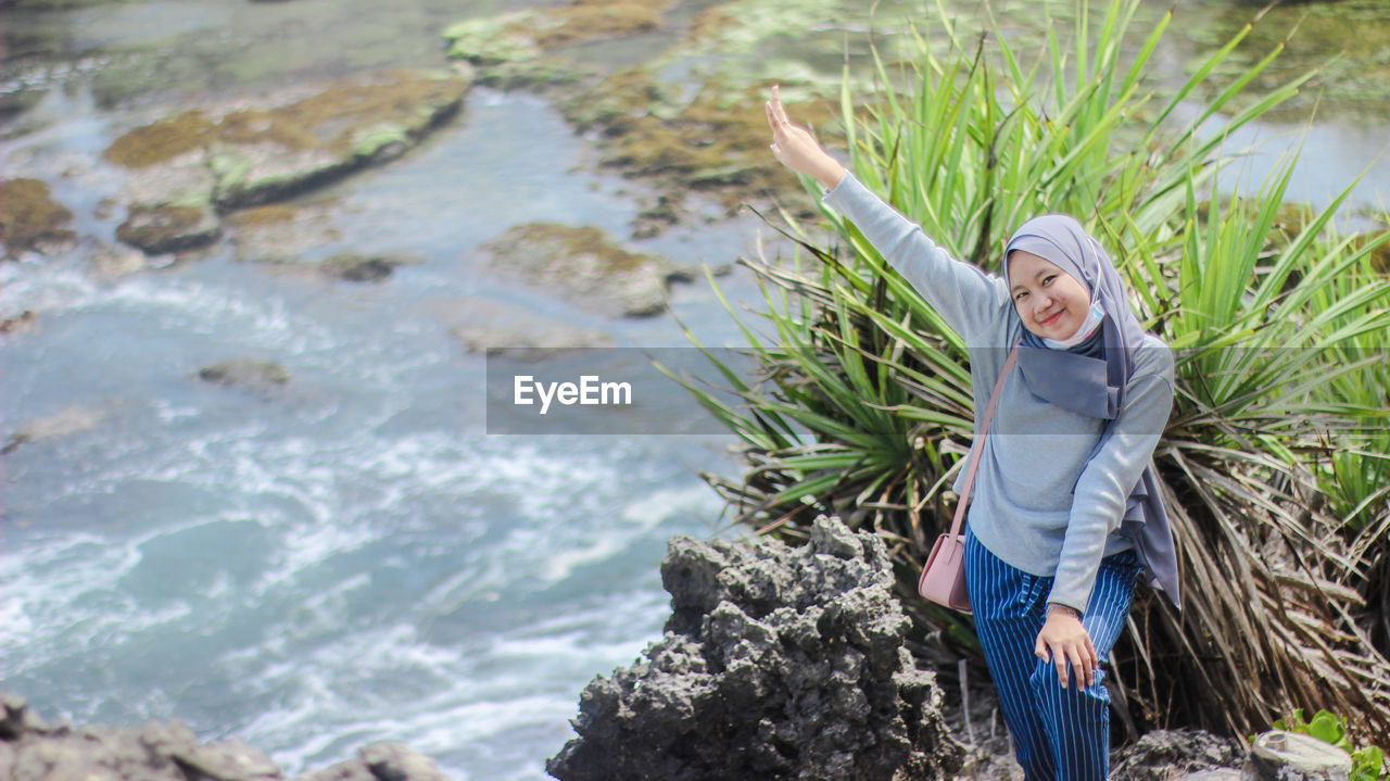 Portrait of smiling woman standing by river