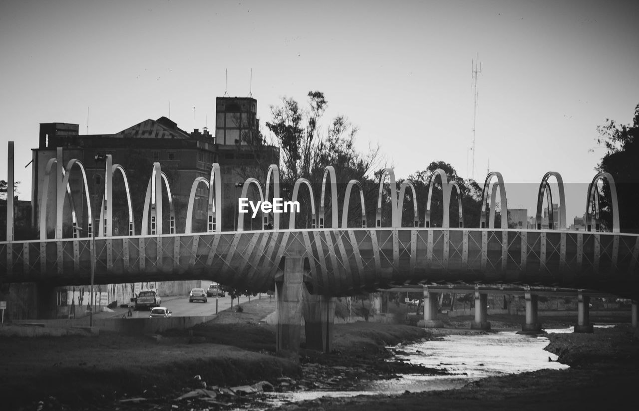 ARCH BRIDGE OVER RIVER AGAINST BUILDINGS