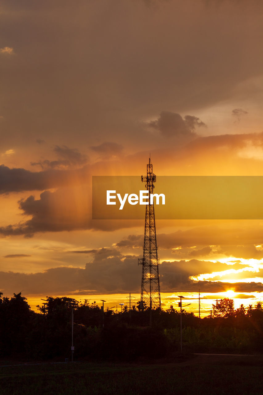 SILHOUETTE ELECTRICITY PYLON ON FIELD DURING SUNSET