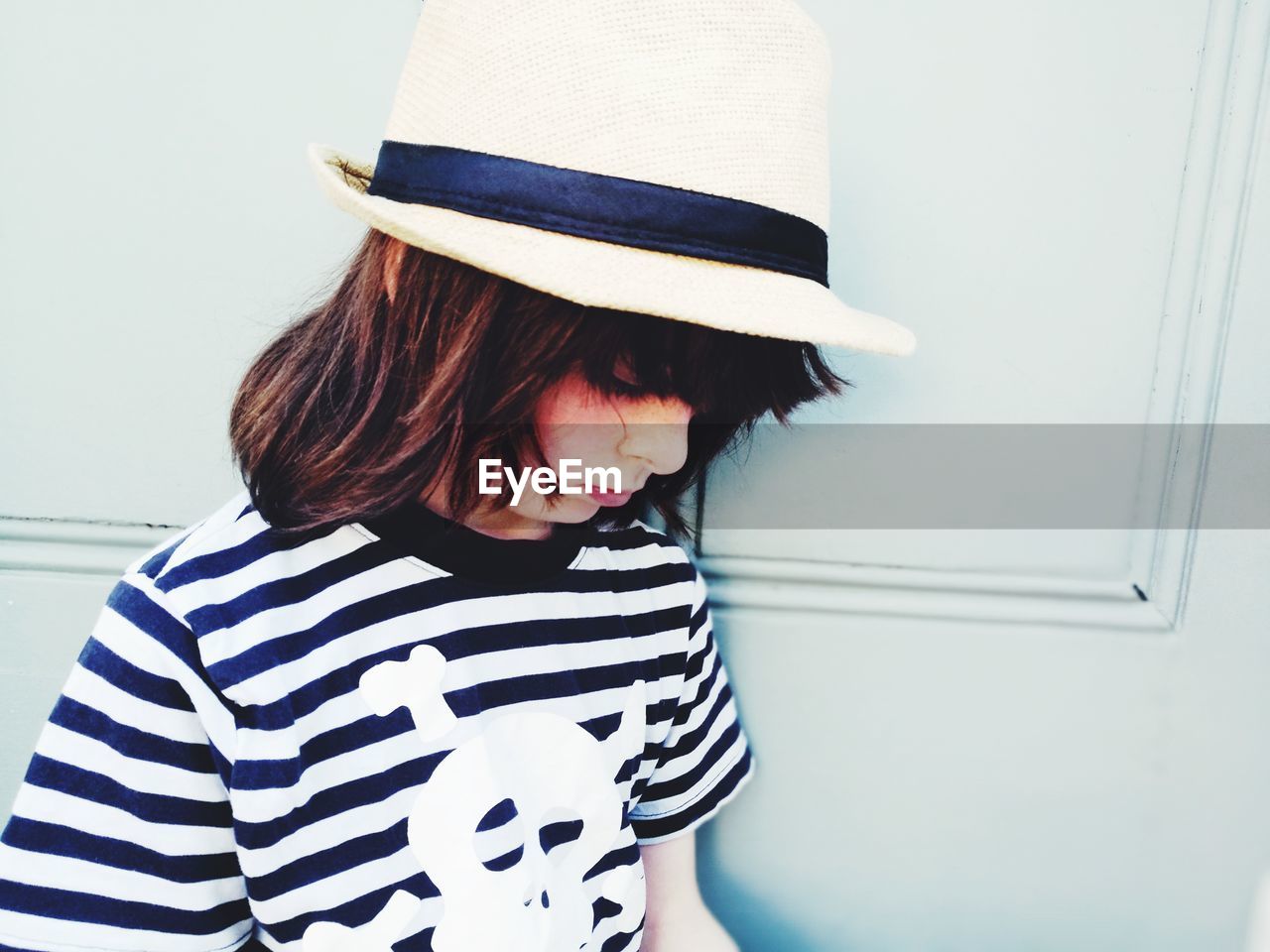 Boy wearing hat against wall at home