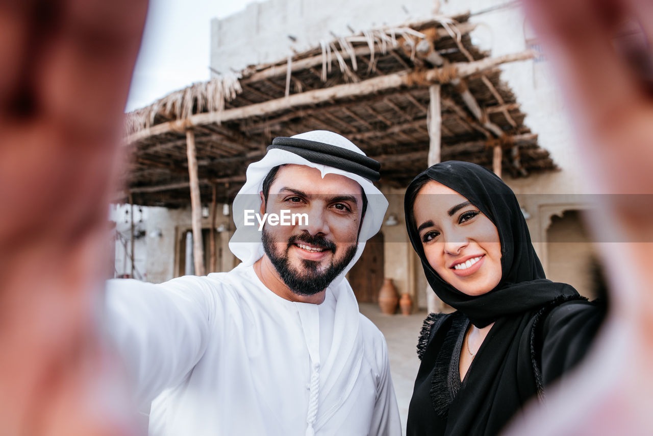 Portrait of smiling couple making hand sign