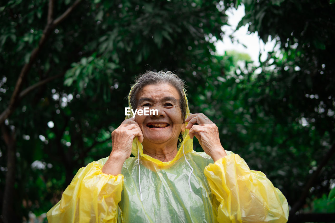 Portrait of smiling woman against trees