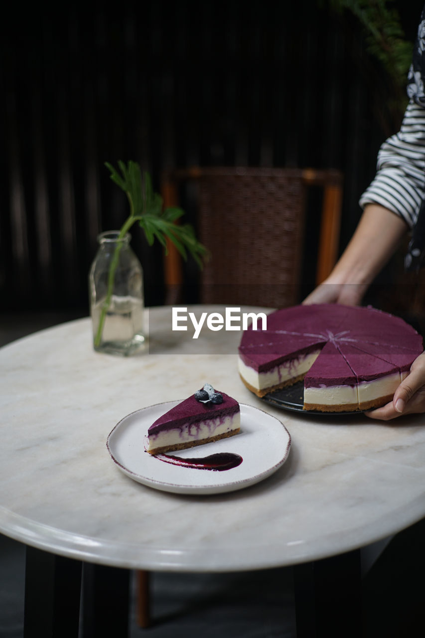 Midsection of woman holding cake in plate