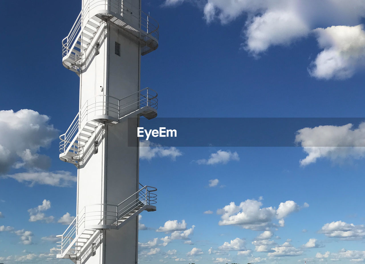 LOW ANGLE VIEW OF TELEPHONE POLE AGAINST BUILDING