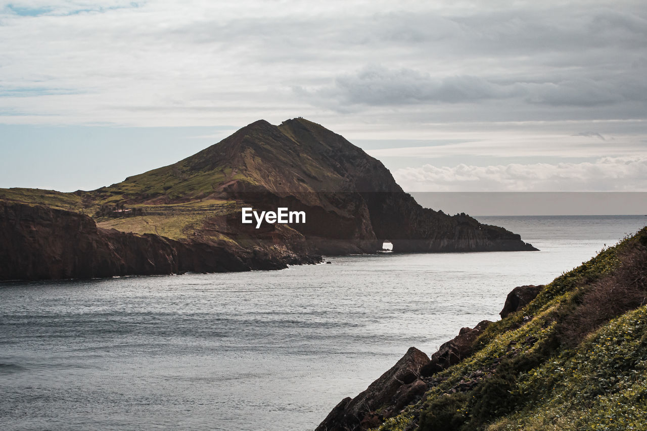SCENIC VIEW OF SEA BY MOUNTAINS AGAINST SKY