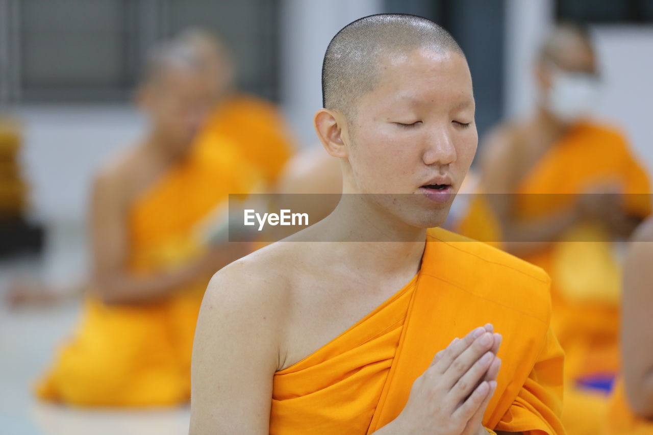 Close-up of monk praying in temple