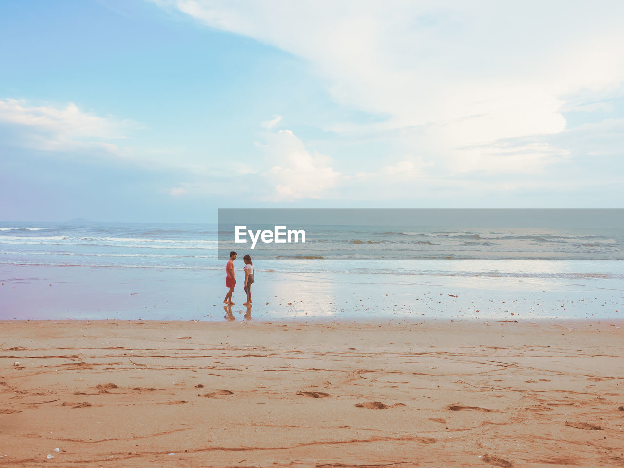 Happy romantic couple enjoying beautiful sunset walk on the beach. pastel colors tone