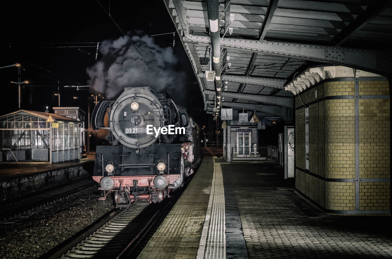 Locomotive train on railroad station platform at night