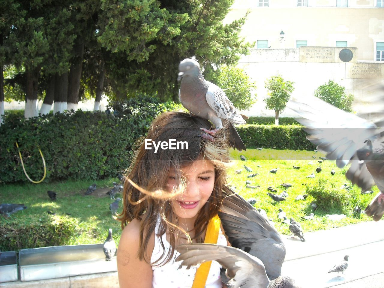 PORTRAIT OF YOUNG WOMAN STANDING ON TREE