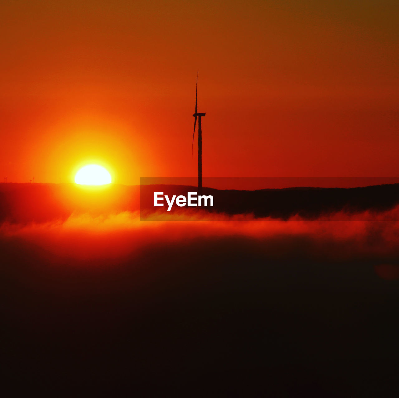 SILHOUETTE OF WIND TURBINES DURING SUNSET