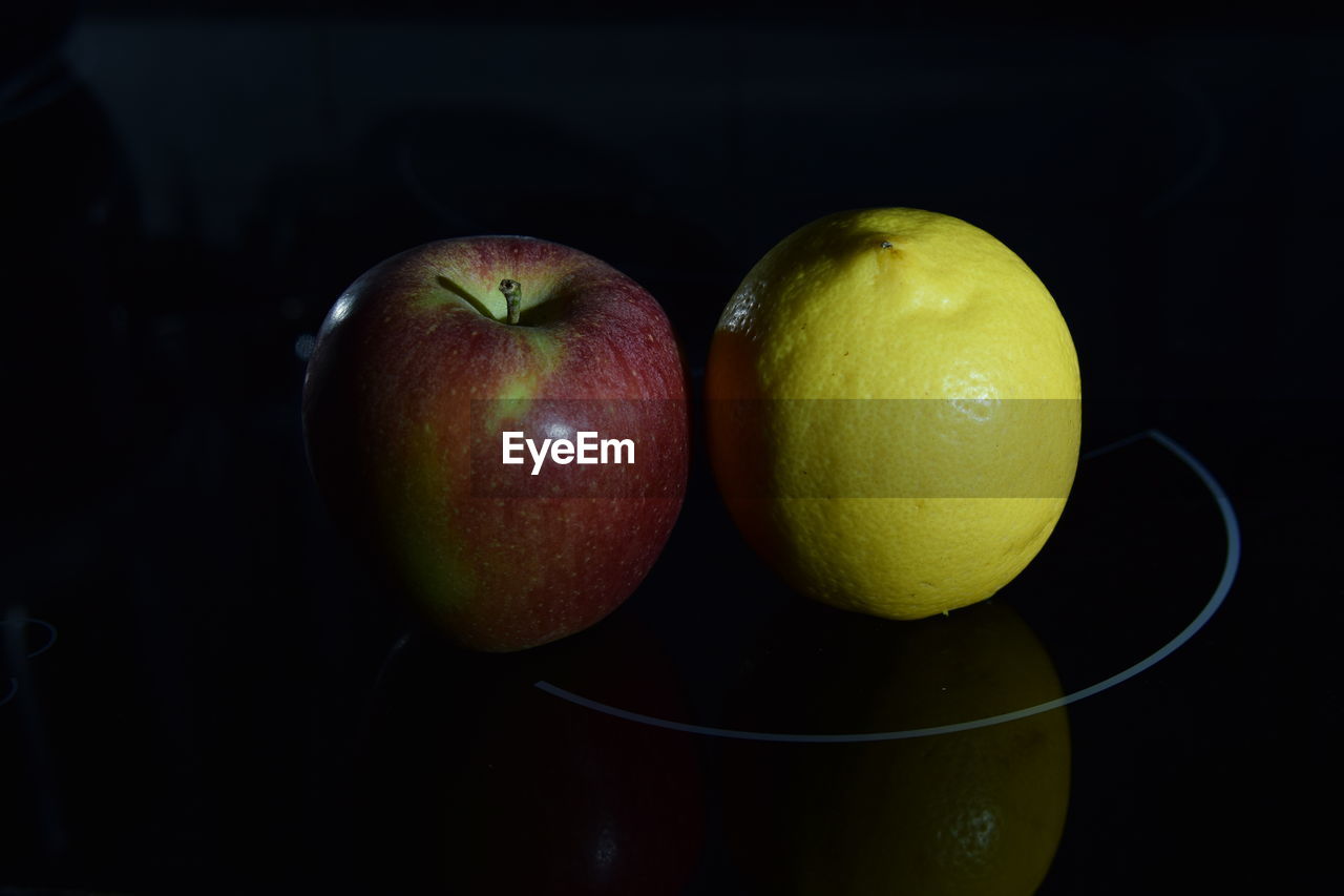 Close-up of apple on table against black background