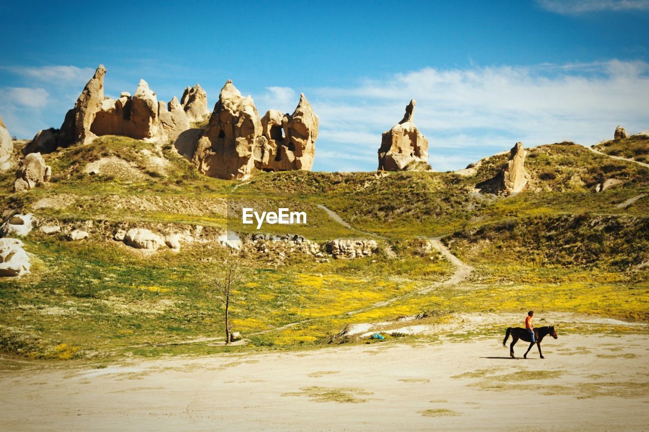 Man riding horse against fairy chimneys