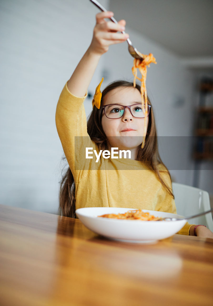Portrait of teenage girl eating food at home