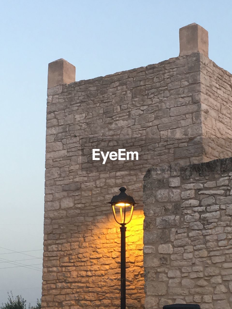 LOW ANGLE VIEW OF STREET LIGHT AGAINST BUILDING WALL