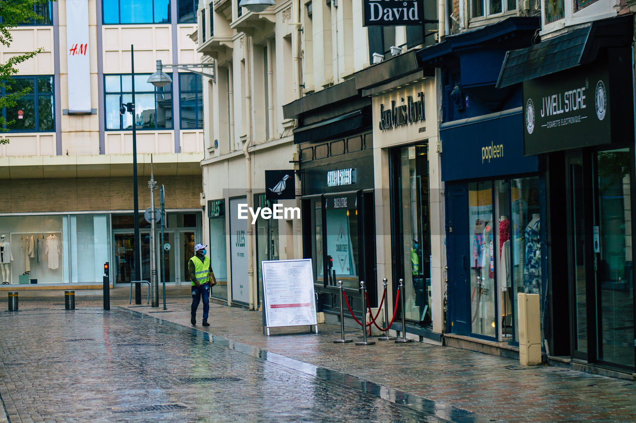 Reflection of building on wet street in city