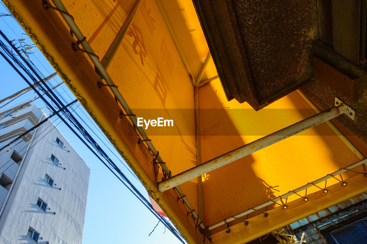 CLOSE-UP LOW ANGLE VIEW OF YELLOW BUILDING