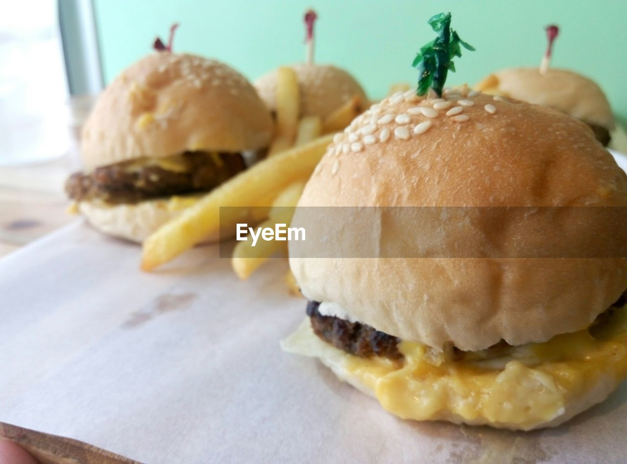 Close-up of fries with burgers on table