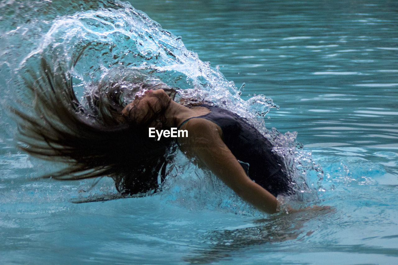 Girl tossing hair in swimming pool