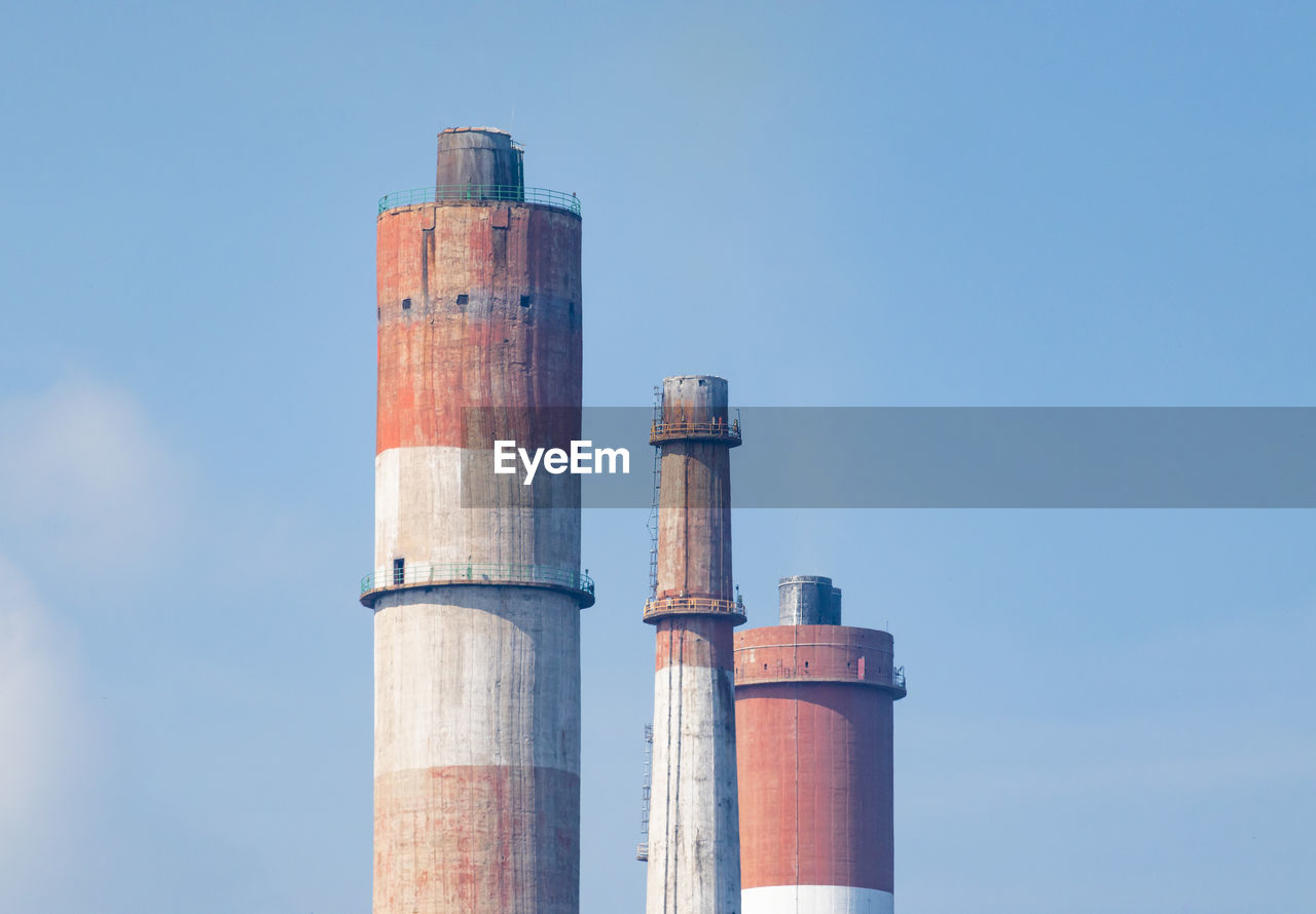 Low angle view of smoke stack against sky