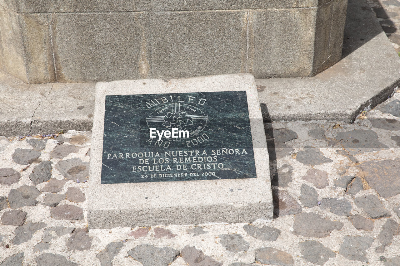 HIGH ANGLE VIEW OF TEXT WRITTEN ON CONCRETE