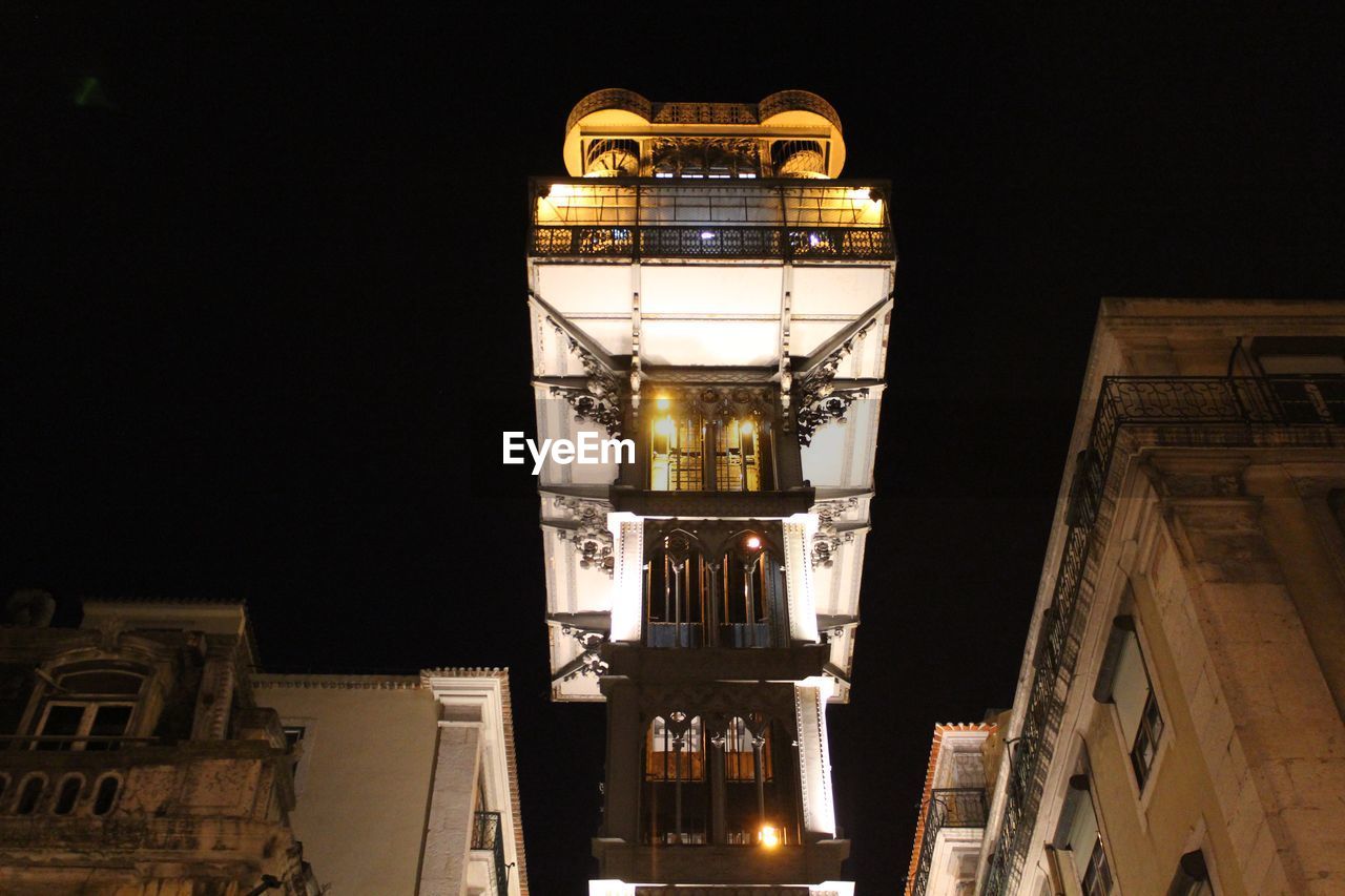 Low angle view of illuminated buildings against sky at night